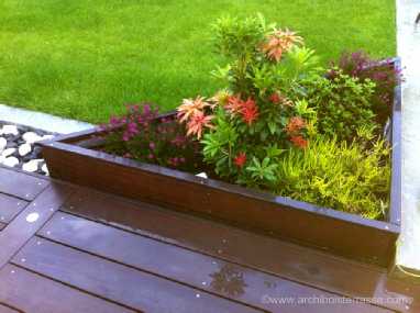 Bac à fleurs en bois triangulaire réalisé sur-mesure près d’une piscine bac fleur sur mesure