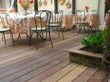 Les jardinières en brique de cette terrasse de restaurant dans une cour intérieure sont parées de bois - nous prêtons attention à tous les détails esthétiques terrasse restaurant dans une cour interieure